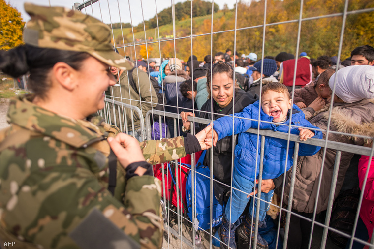 Egy szlovén rendőr játszik egy menekült kisfiúval az osztrák-szlovén határon, 2015. október 25-én.