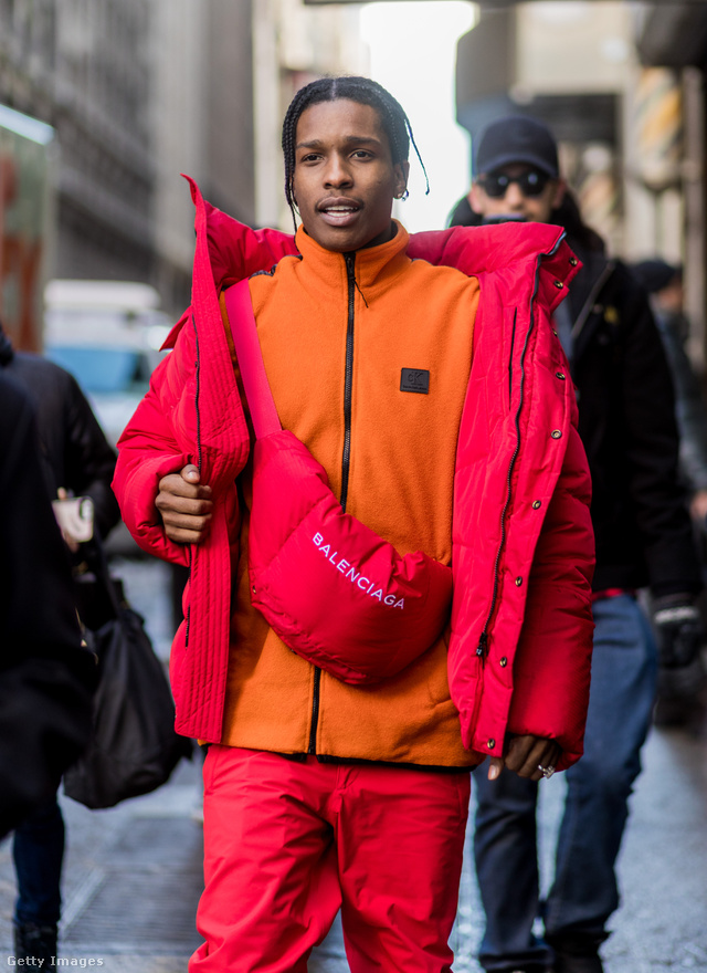 Asap Rocky narancssárga, cipzáras Balenciaga felsőben és Calvin Klein pufidzsekiben a februári divathéten New Yorkban.
                        