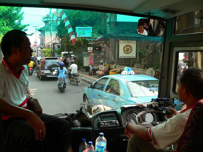 The Ubud bus arriving at Denpasar. One storey stores sell handcrafted souvenirs; the narrow sidewalks are full of tourists, while the street is inhabited by scooters, off-road vehicles and a Blue Bird taxi. Cab drivers are quick to cheat gullible customers, so you are better off agreeing on the fare before setting off - but first check on the internet how much you should be paying. Most people agree that Blue Bird is the most reliable of all taxi companies, they operate metered cars. A quick glimpse at the dashboard will tell you that Indonesia is a right-hand-drive nation. Not only that, European will find Balinese traffic shocking because drivers tend to be creative in adhering to the laws and regulations.