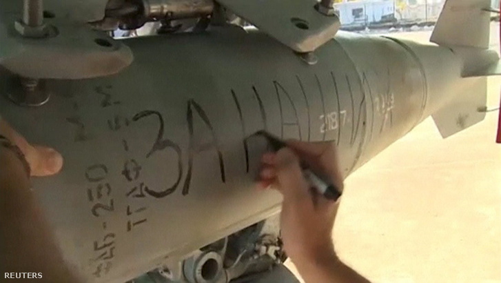 "A mieinkért" olvasható ezen a bombán, amit Szíriában erősítenek egy orosz bombázó szárnyai alá a Hmeimim támaszponton. Egy másik bombára azt írták: "Párizsért."