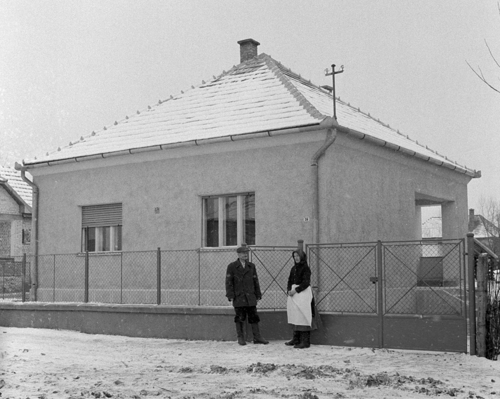 Sike Keskeny József ötgyermekes nyugdíjas mikófalvai lakos és felesége a lottón nyert családi házuk előtt az ünnepélyes átadás napján. Mikófalva 1960. január 12.