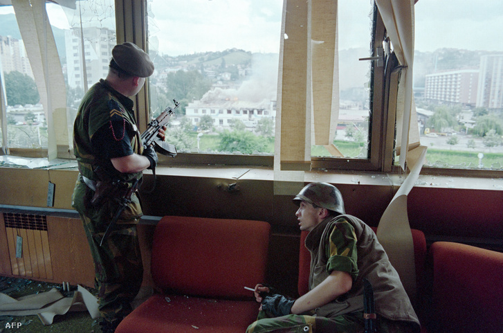 Boszniai lövészek egy szarajevói toronyház kilőtt ablaka mögött.
