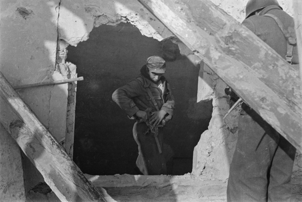 Köztársasági katona egy szétlőtt épület romjai között a Teruel-i csata után. A sorozat következő képein Capa katonákkal járja be az épületet, az egyik kockán azt is látni, ahogy a toronyház emeltén a romok takarásából kémlelik a tájat egy ellenséges mesterlövész után kutatva.