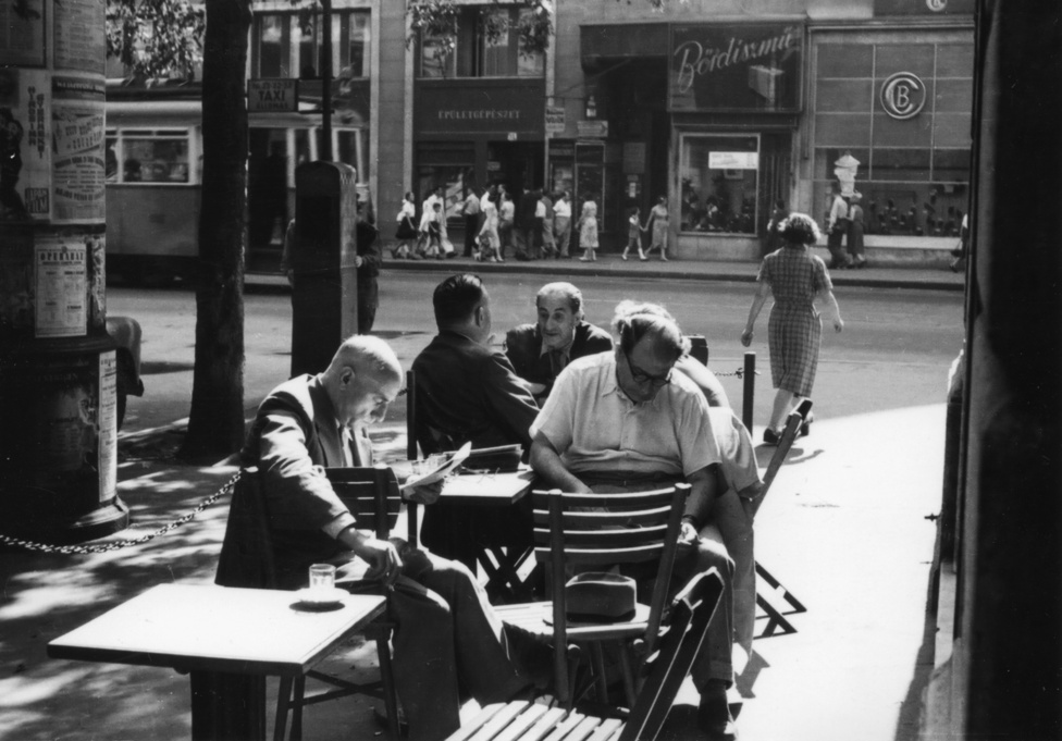 Amikor még vígan korzóztak az emberek a Kossuth Lajos utcában, s a Semmelweis sarkán az utcára kitett asztaloknál itták a feketét. A háttérben egy japán film és egy operabál plakátja. Mintha csak Olaszországban járnánk. Pedig azért 1955-ben nem lehetett valami vidám hely Budapest.