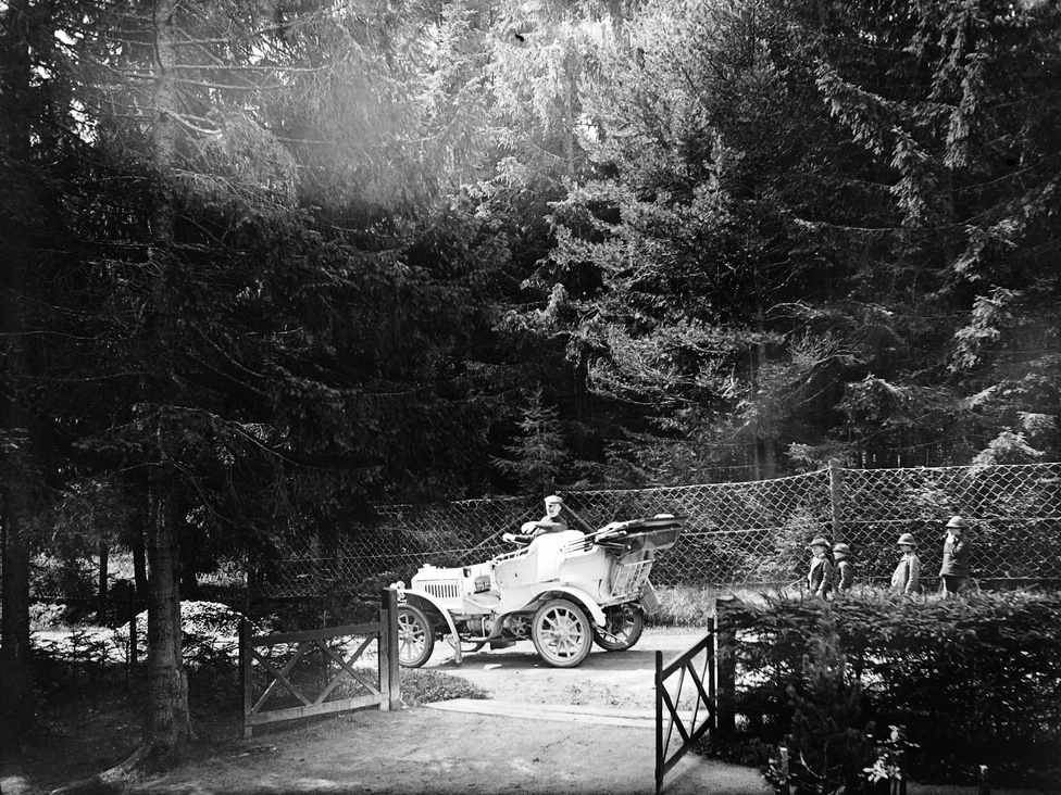 A fenyvesekből ítélve talán ez a kép is a Tátrában készült - egyébként az egyik első magyar autóverseny is ide vezetett Budapestről; az út akkor szinte annyi megpróbáltatással járhatott, mint most egy Párizs-Dakar rali. Az itt látható autó egy Mercedes, de még nem Benz, a típus a gyáregyesülés előtt készült. A gépkocsi tulajdonosa a Magyar Automobil Club 1906-os évkönyve szerint gróf Zichy Béla Jenő.