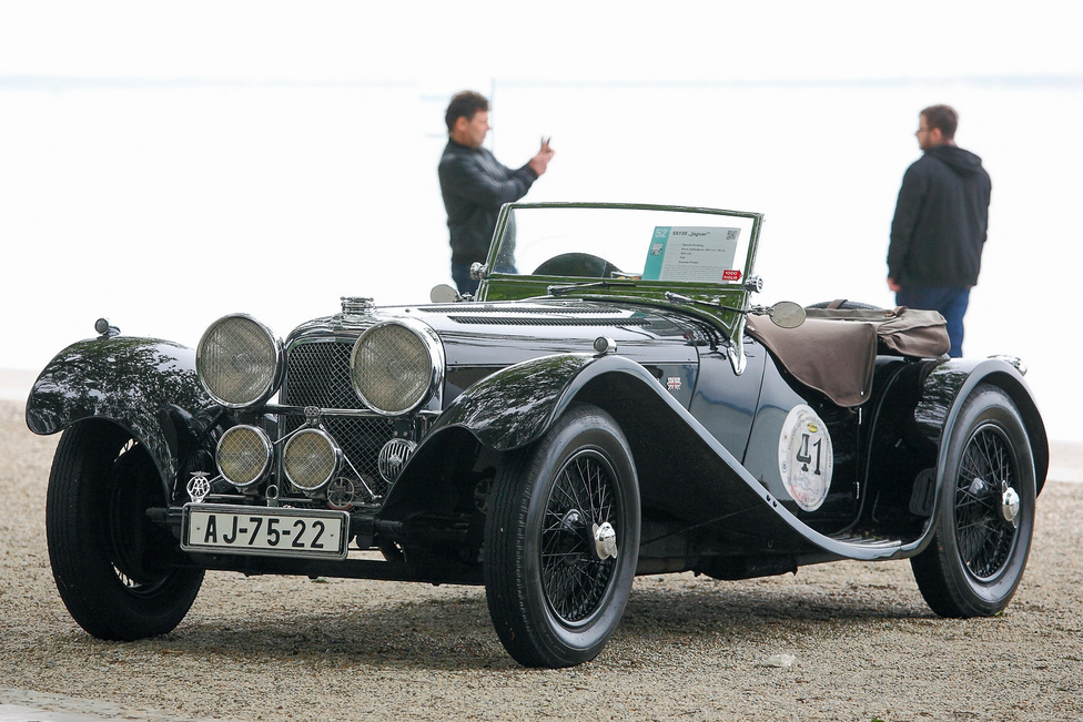 Balatonfüred legszebb nyitott autója: SS 100 Jaguar (1936). A cég kezdetben Swallow Sidecars néven futott, de a második világháború idején az SS név nem volt valami népszerű Nagy-Britanniában, ezért 1943-tól hivatalosan felvették a Jaguar nevet – a nagymacska addig csak hűtődíszként ugrált a kocsi orrán. Elég gyorsan, mert ez volt az első típusuk, amely megfutotta a 100 mérföld per órát (161 km/h). 