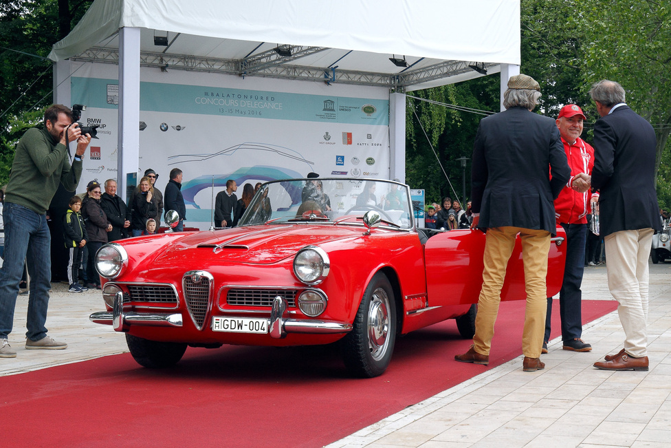 A Classic kategória legszebb nyitott kocsijának járó díjat veszi át az Alfa Romeo Touring Spider 2000 (1959) tulajdonosa. Ez az, amiben az olaszok mindig az élen jártak, az elegancia és a sportosság harmonikus, szemet gyönyörködtető ötvözése. A kétliteres, dupla vezérműtengelyes motor 115 lóerős, ötfokozatú váltón keresztül hajtja a hátsó kerekeket. A karosszéria a milánói Touring műhely munkája, 1962-től a hathengeres 2600 Spider váltotta fel.