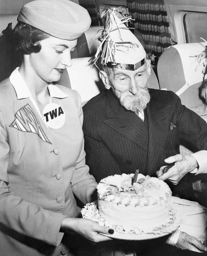 Suzy Smith, a TWA egyik legendás stewardesse Ward Elmore ezredes társaságában, aki élete első repülőútjára indult a társaság San Franciscóban átadott, 15 millió dollárból felépített termináljából 1958 augusztusában. Ez volt a TWA első járata, ami innen szállt fel, az ezredes, aki a gépen ünnepelte 100. születésnapját, nagyon élvezte az utat. A hosszú élet titkáról azt mondta, hogy sokat énekelt, és amikor énekelt, mindig ivott hozzá, ami segített. Sajnos soha nem utaztam TWA-járatal, de az egyik Párizs-Lagos úton én is kaptam tortát, 12 éves voltam. Mondom, az UTA pompás légitársaság volt.