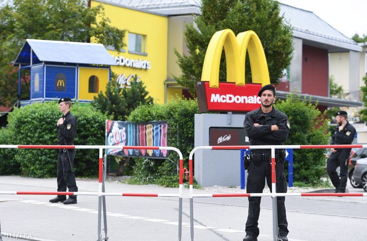 Rendőrök a müncheni olimpiai parkban található Olympia bevásárlóközpont mellett lévő gyorsétterem előtt 2016. július 23-án egy nappal az épületben történt lövöldözés után.