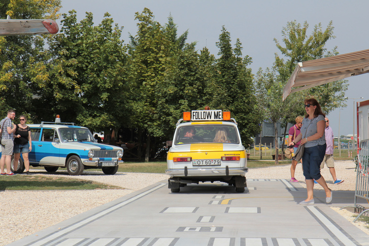 Az Aeropark büféje előtt mini leszállópályán mozognak a régi reptéri járművek