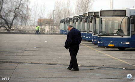Egy buszvezető sétál a parkoló buszok előtt BKV cinkotai buszgarázsában a főváros XVI. kerületében. 