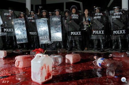 THAILAND, Bangkok : Thai riot policemen stand in a pool of blood after supporters of deposed Thai premier Thaksin Shinawatra spilled blood they had collected at Prime Minister Abhisit Vejjajiva's residence as part of an anti-government protest in Bangkok on March 17, 2010.  Thai protesters poured bottles of their own blood at the gates of the prime minister's residence but their four-day rally backing their ousted political hero appeared to be dampening. 