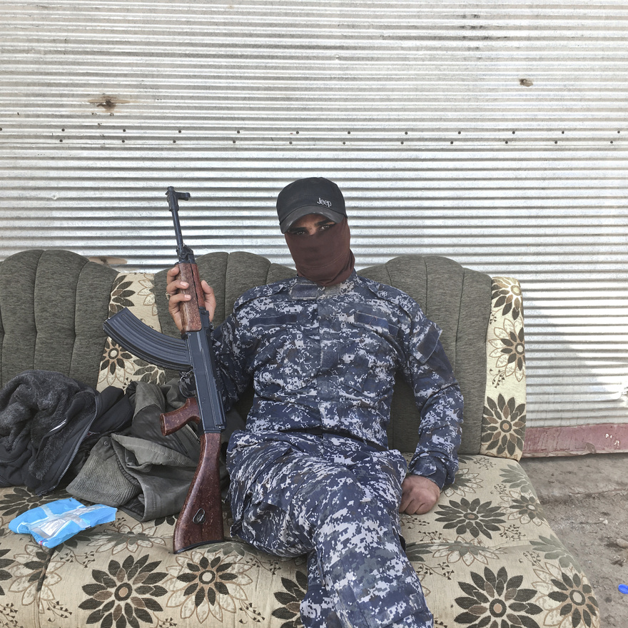 Abduljuszef az Iraki Állami Rendőrség egyenruhájában pózol egy Moszul melletti faluban, 40 kilométerre a harcoktól.
