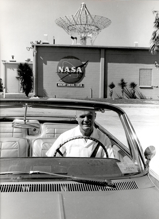 Floridai napfényben: Glenn autójában, a háttérben a Mercury vezérlőközpont.