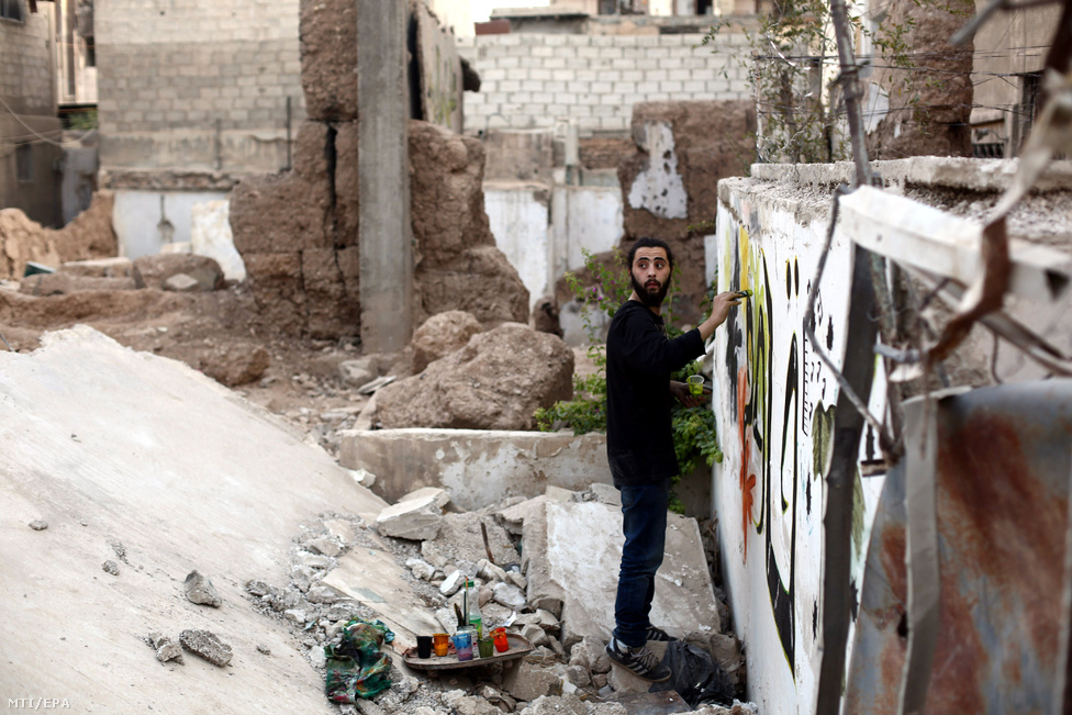 Noor szíriai graffitimûvész dolgozik legújabb alkotásán a főváros Damaszkusz Kabun negyedében.