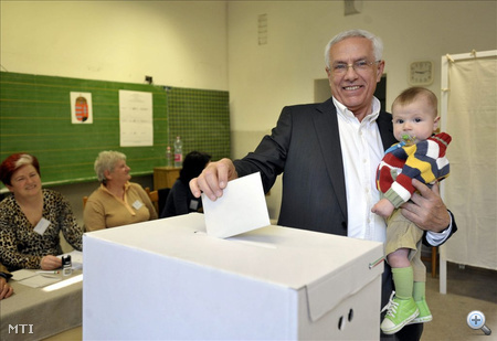 Szalay Péter a Fidesz képviselőjelöltje Olivér nevü unokájával a karján bedobja a szavazólapot a budapesti 19-es választókerület 16-os szavazókörében, a XIII. kerületi Hermann Ottó általános iskolában.