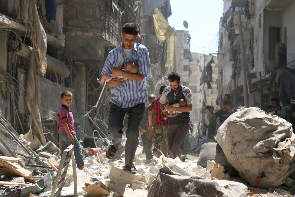 Gyerekeket cipelő szíriai férfiak egy aleppói utcán. A kép szeptemberben készült a város egyik felkelők által ellenőrzött negyedében, egy légicsapás után, amit vagy a szíriai kormány vagy az őket támogató orosz hadsereg indított. A kisbabákat cipelő szíriai férfiakról készült kép az öt éve tartó konfliktus egyik legszívszorítóbb darabja, szeptember óta több száz cikkben jelent meg illusztrációként, nem nehéz belátni, hogy miért.Aleppó a szíriai 
                        polgárháború előtt 2,5 milliós város volt, Szíria 
                        legnépesebb települése, a szunnita-arab Damaszkuszhoz 
                        képest egy soknemzetiségű, sokvallású metropolisz. 2012
                        -ben nyomultak be az Aleppó körüli településekről az 
                        ellenzéki harcosok a város keleti felébe, amire az 
                        Aszad-rezsim a rendszeressé váló megkülönböztetés 
                        nélküli bombázással és tüzérségi tűzzel reagált. Az 
                        évekig tartó harcokba bekapcsolódtak a Hezbollah 
                        harcosai, az aleppói kurd negyedet szilárdan megszállva 
                        tartó kurd milícia, az YPG, valamint az al-Kaida szíriai 
                        fiókszervezetének, az an-Núszra Frontnak a dzsihadistái 
                        is. 2013-tól északkelet felől megjelentek a felívelőben 
                        lévő Iszlám Állam dzsihadistái is, akik sorra vették be 
                        Aleppó keleti elővárosait. A mérhetetlen pusztítással 
                        járó aleppói helyzetet egy képzeletbeli Budapestre 
                        átvetítve itt 
                        értheti meg jobban.
                        
                        Az erők egyensúlya 2015 végén, az Aszadot támogató orosz 
                        intervencióval tört meg. A névleg a terroristákat, de 
                        valójában az Aszad-ellenes erőket célzó légioffenzívának 
                        köszönhetően 2016 február elejére sikerült elvágni a 
                        város keleti, ellenzéki negyedeit az egyik legfontosabb 
                        ellenzéki szponzornak számító Törökország felé tartó 
                        korridortól. A februári fegyverszünet 53 napját követően 
                        egyre szorult a hurok Aleppó ellenzéki része körül, és 
                        igazából nem volt kérdés, hogy a város előbb-utóbb Aszad 
                        kezére jut majd. Ez végül december elején történt meg, 
                        itt 
                        foglaltuk össze részletesen, hogy mi következik 
                        2017-ben.