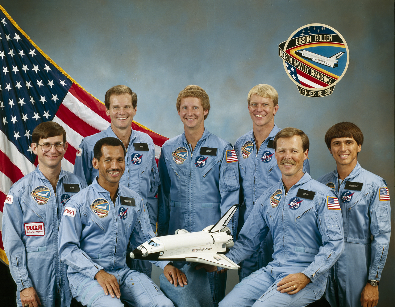 1985. december 8-i hivatalos csoportképen az STS-61C küldetés hét űrhajósa.
                        A Columbia modellje mellett balról Bolden, a pilóta, jobbról Robert L. (Hoot) Gibson, a küldetés parancsnoka. Körülöttük balról jobbra: Robert J. Cenker, Bill Nelson (kongresszusi képviselő), valamint Steven A. Hawley, George D. Nelson, és Franklin R. Chang-Diaz.
