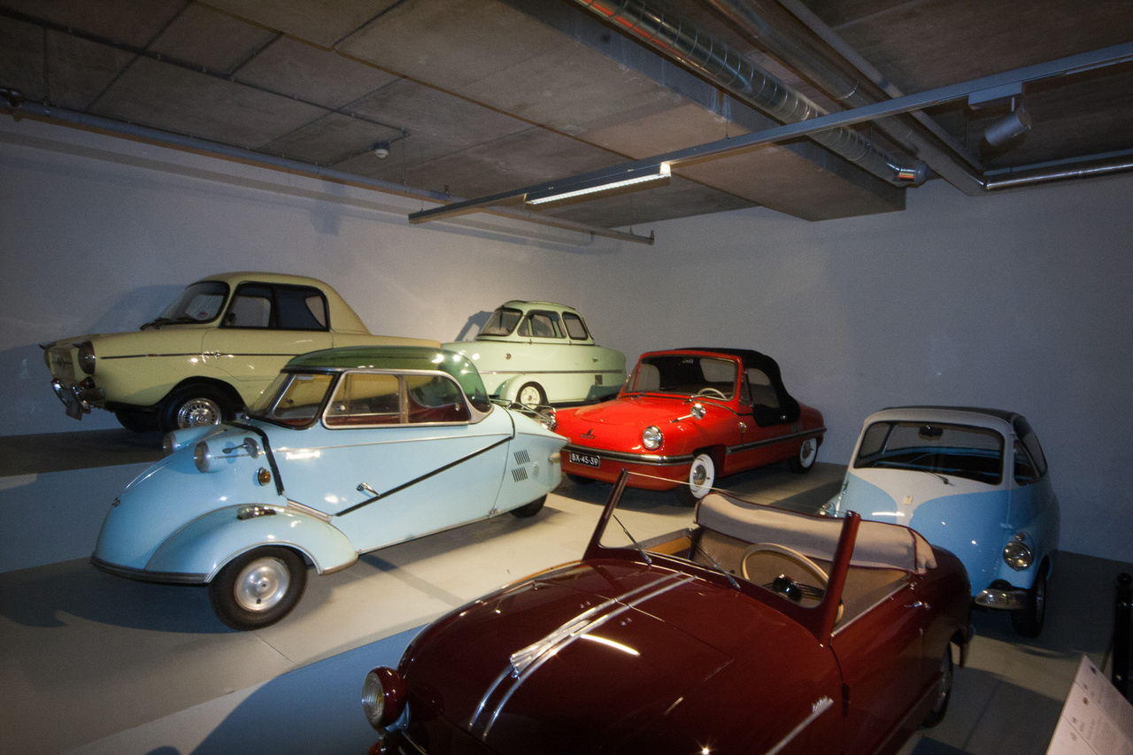 A másik minimálautó-terem egy sarka: a felső polcon Frisky Family Three (1960), Inter Cabin Scooter (1955), alatta a Messerschmitt Kabinenroller KR200 (1959), Spatz (1956), majd legalul a már említett Rovin, mögötte egy Isetta, de nem a BMW-féle, hanem még az eredeti, olasz ISO-gyártmány.