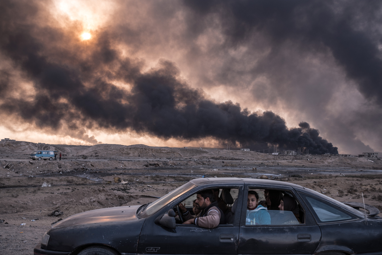 Kiemelt hírek (sorozat) III. helyMoszul ostroma elől menekülő iraki civilek a várost elkerülő autóúton. A háttérben a füst és a lángok a város körül felgyújtott gyárakból és olajmezőkből szállnak fel.