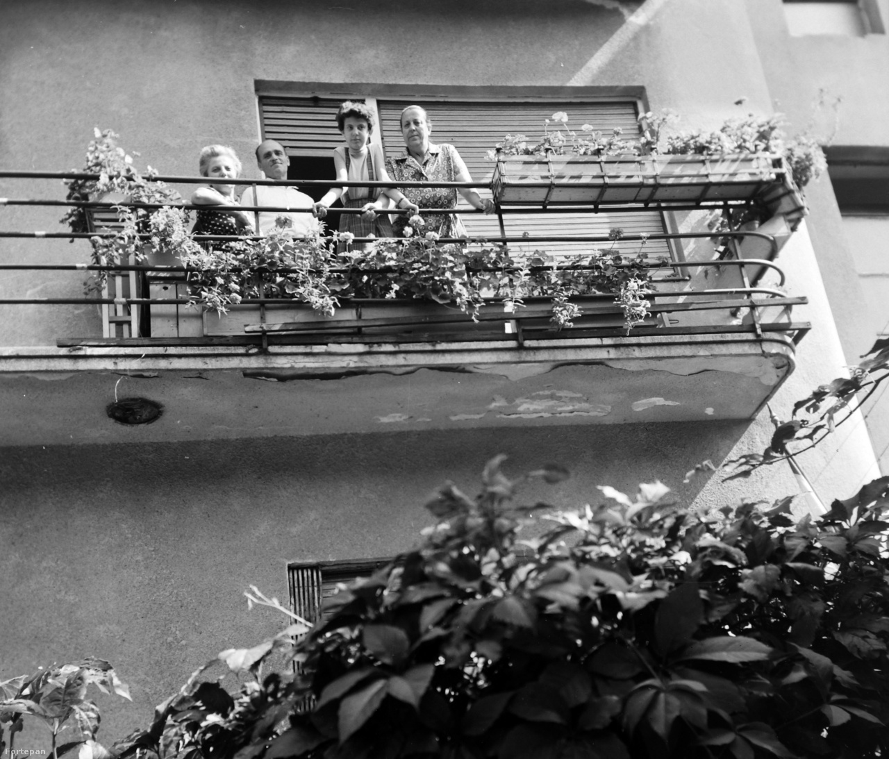 A terasszal szemben az erkély a levegőben lóg. Ha megnyílna alattunk, akkor nem egy szobába pottyannánk, hanem a kertbe vagy az utcára. Esetleg az alattunk levő erkélyre. Az erkély mindig kilóg a ház homlokzatából, mint ahogy ezen az 1963-as fotón is látszik a budapesti Hollósy Simon utcában.
