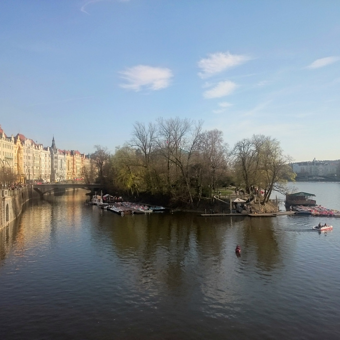 Tekerjen a folyón a prágai napsütésben