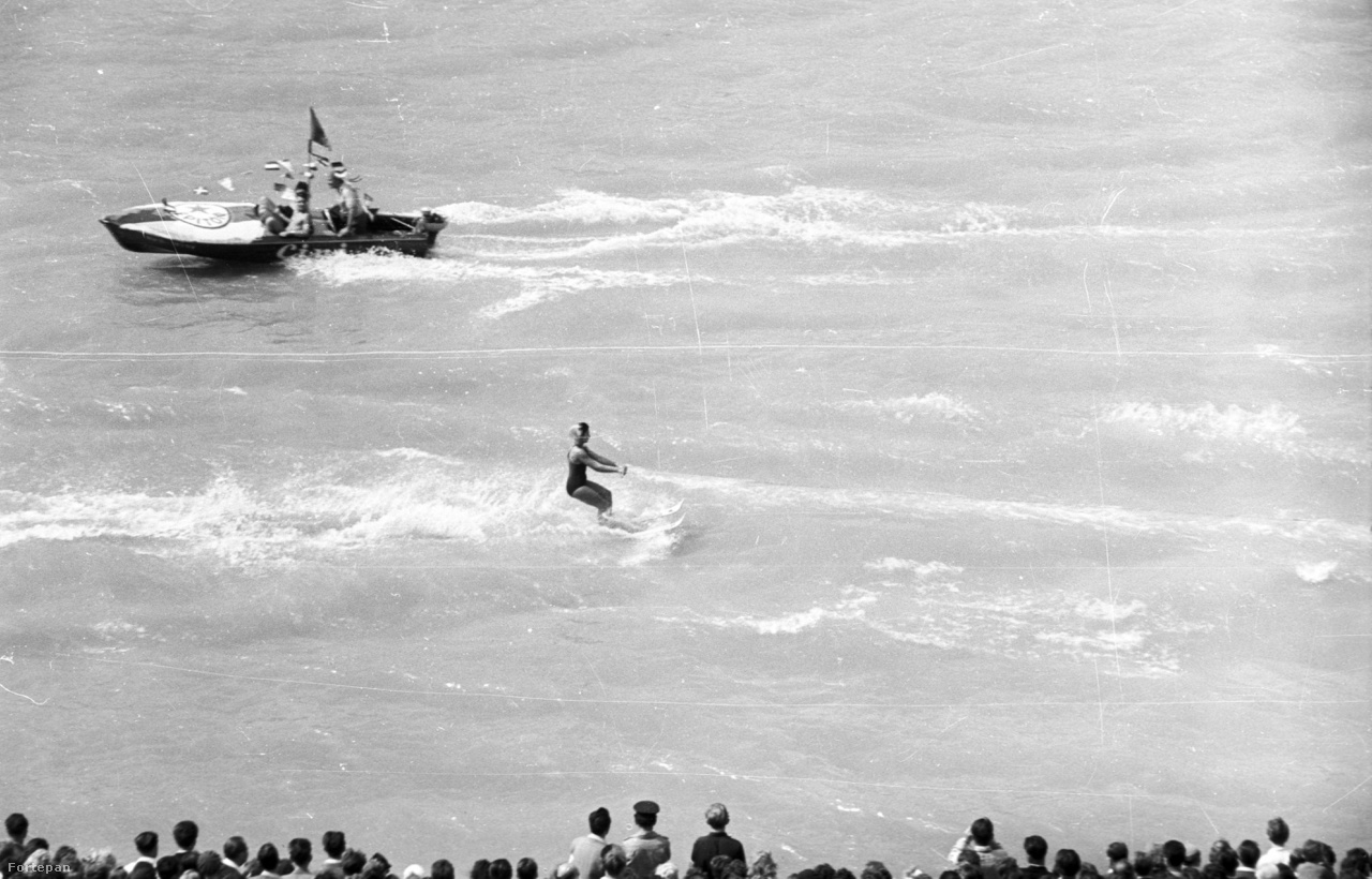 Vízisí bemutató augusztus 20-án a Széchenyi rakparttól nézve, 1960
                        Már 11 éves a magyar Alkotmány! Augusztusi napsugárözönben, nagyszabású dunai vízi parádéval, kétszázezer lelkes nézővel ünnepelt a Népköztársaság.