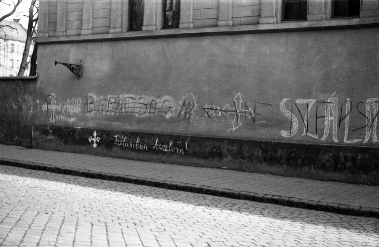 A Roncsfilmből ismerős lehet a Gólya nevű söröző, ez ugyanabban a Bókay János utcában lévő volt fiúárvaház, a Josefium épülete. Itt valaki már 1944-ben erőteljesen opponálta az akkori szálasista graffitit. Érdemes megfigyelni, hogy ez a nyilas művész már magabiztosan ismerte a betűket, és gyermekibb rajzokkal és logókkal is megpróbálta feldíszíteni az üzenetét. Az ideológiai opponens pedig először talán csak a tagadásban hitt, aztán némi ellenüzenetet is oda akart tenni.  