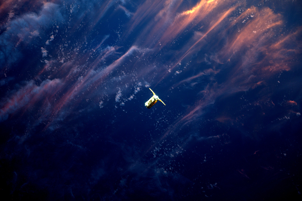Az ISS-ra tartó Cygnus teherűrhajó, földi naplementével a háttérben.