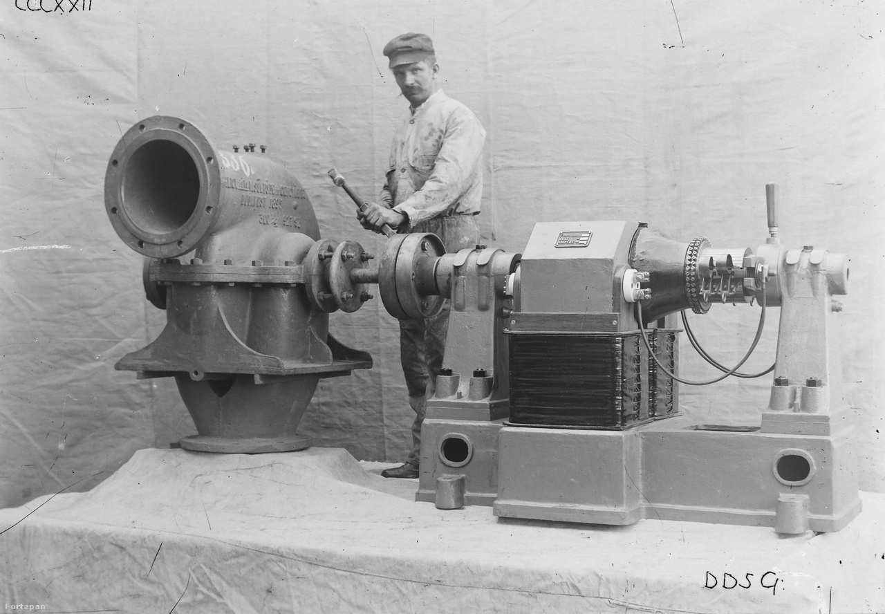 1895-ben készül öntöttvas Ganz turbinával és a hozzá kapcsolt korszerű elektromotorral pózoló munkás az Óbudai Hajógyárban, talán valamikor 1920 és 1940 között. A kép valószínűleg promóciós céllal készült (brosurába, katalógusba, gyárismertetőbe stb), erre utal a műteremszerű kialakítás, a vászonnal takart háttér és emelvény.