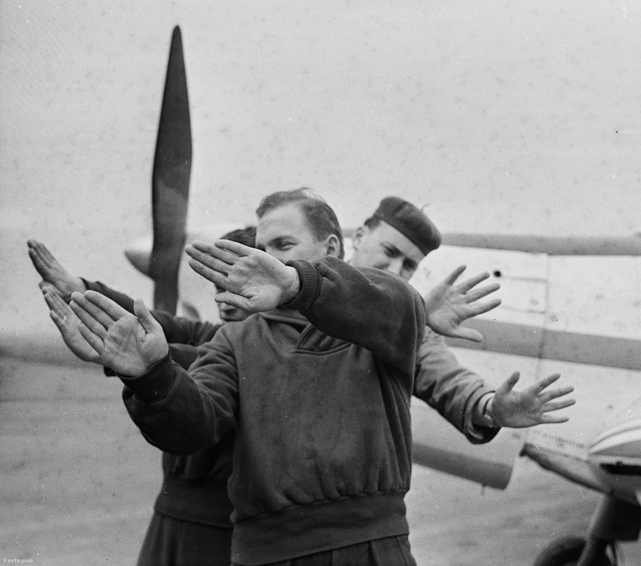 1966. Műrepülők a földön gyakorolják a repülés elemeit. A háttérben egy Zlin Trener típusú repülőgép.