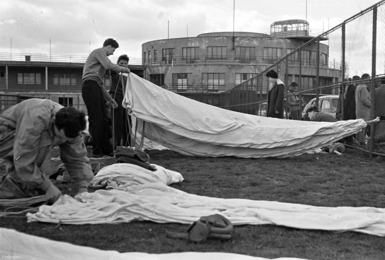 1966. Ejtőernyősök hajtogatják ernyőiket. A háttérben a központi épület, elég leharcolt állapotban.