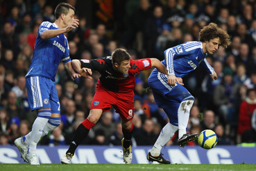 David Luiz (R) and John Terry of Chelsea (L) foil Marko Futacs of Portsmouth during the FA Cup sponsored by Budweiser Third Round match between Chelsea and Portsmouth at Stamford Bridge on January 8 2012 in London England.  