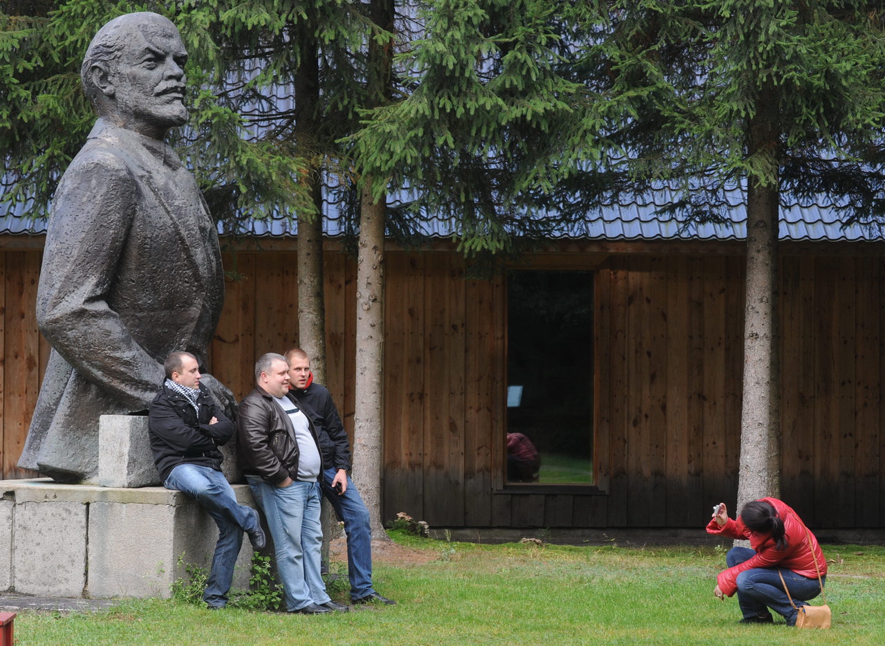 Turisták fényképezkednek Lenin szobrával egy litván emlékparkban, 2008.