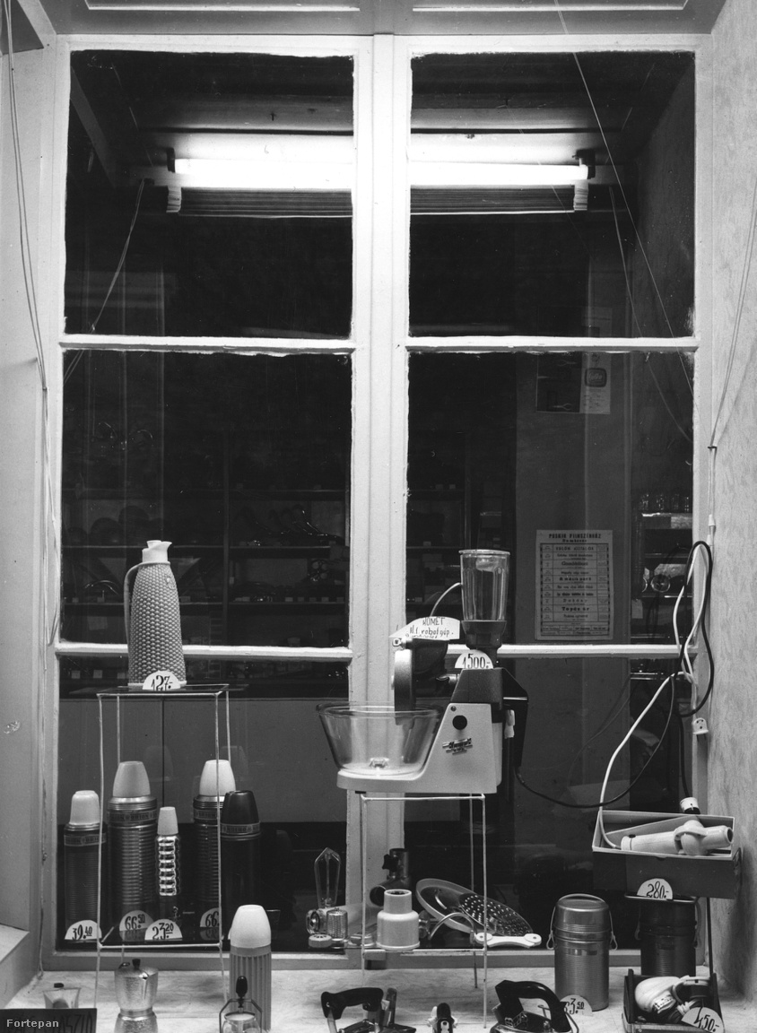 Háztartási bolt kirakata, többféle termosszal, kávéfőzővel, hajszárítóval, vasalóval, és középen, külön állványon üstökös (Komet) márkájú szovjet multifunkciós konyhai robotgéppel (1964).
                        