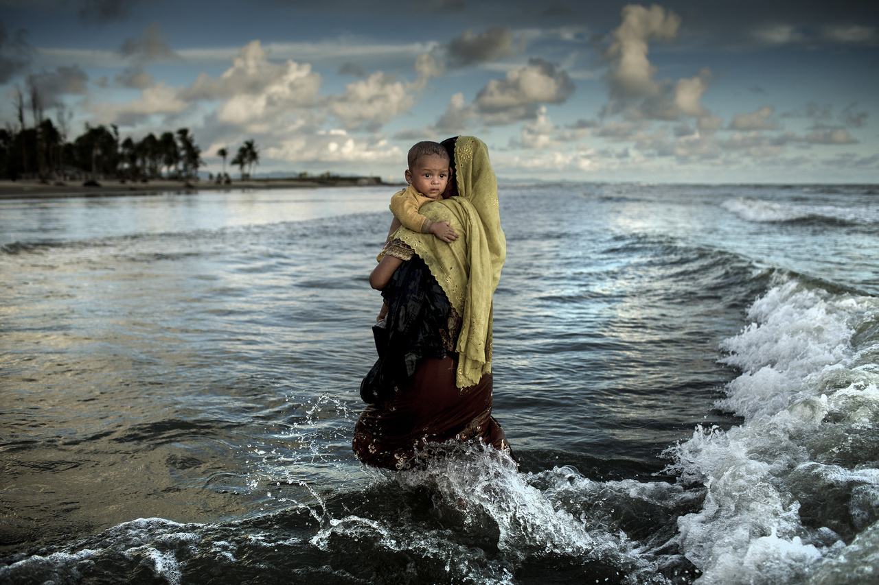 Anya és gyermeke sétál ki a vízből Bangladesben - ketten a több százezer rohingja menekültből, akik a népirtás elől menekültek a szomszédos Mianmarból. A hadsereg kegyetlenkedései nyomán legalább 320 ezer gyermek kényszerült elhagyni az otthonát.
