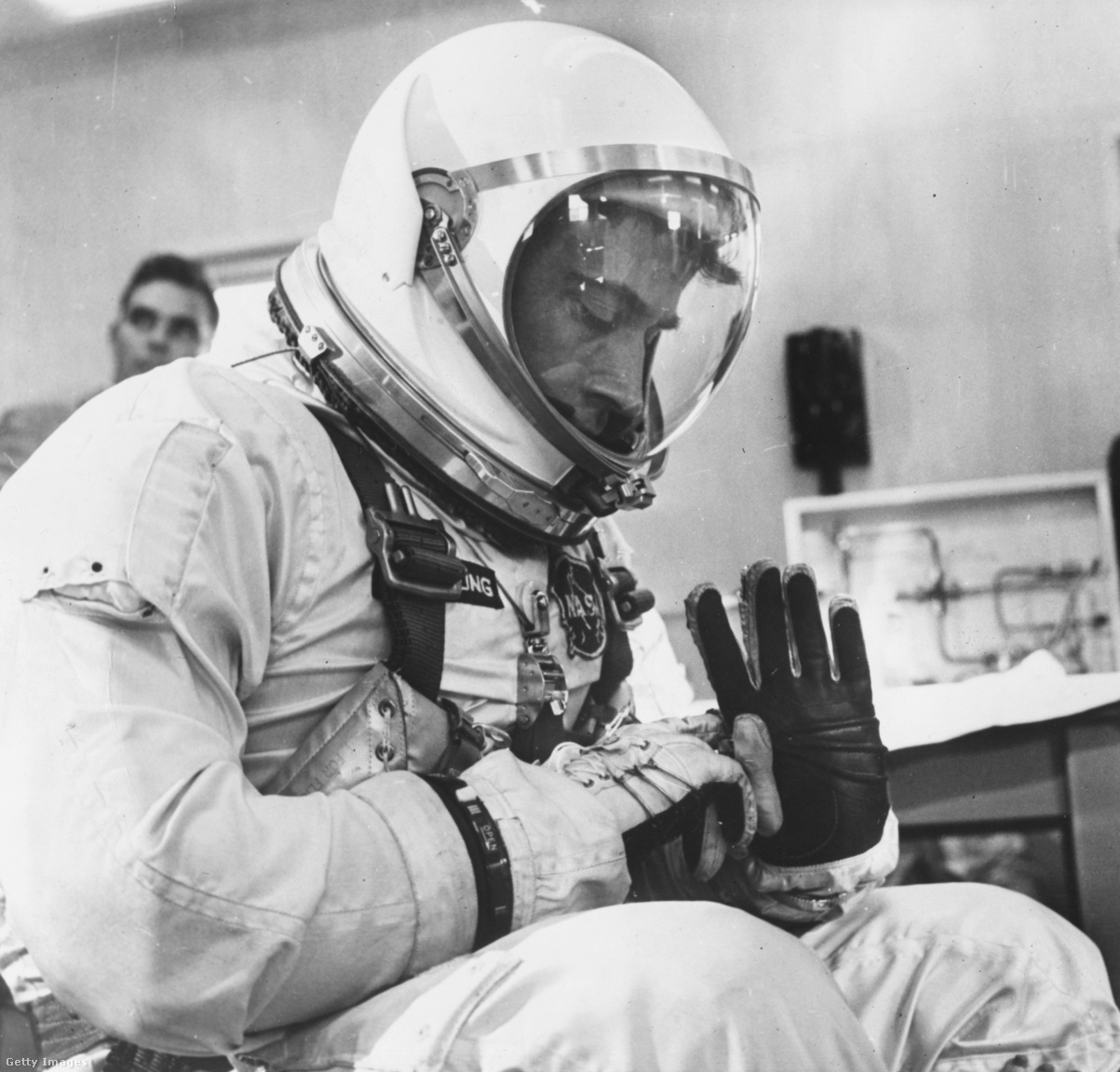 1965. március 23. Young a kesztyűjét ellenőrzi a számtalan szkafanderpróbák egyikén.
                        