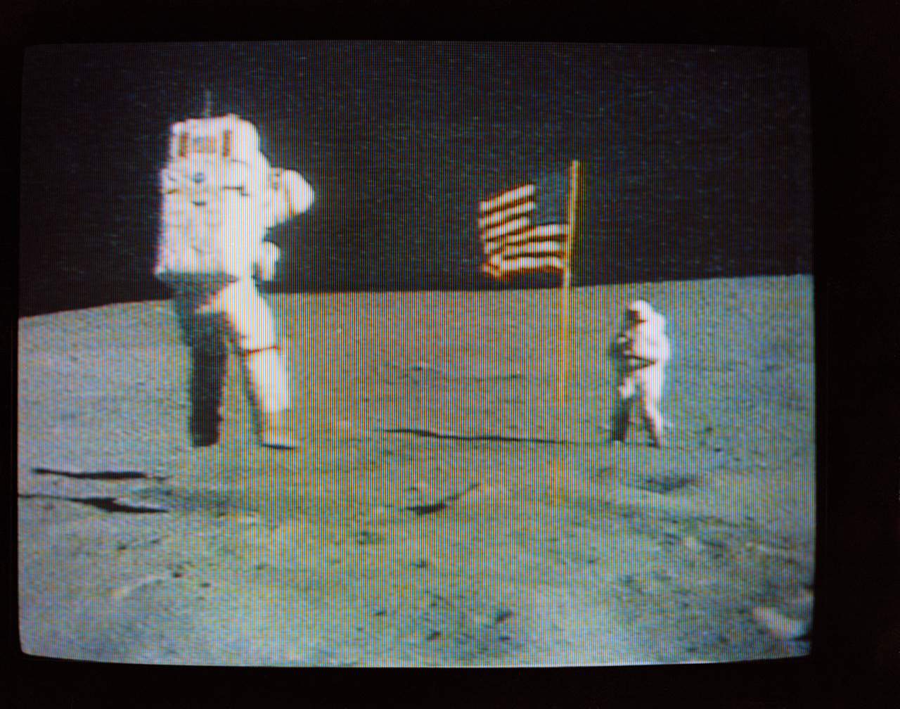 Így készült az előbbi fotó. A Hold felszínéről közvetítő színes tévékamera felvételén látható, amint Duke fényképezi a holdi gravitációval játszó Youngot.