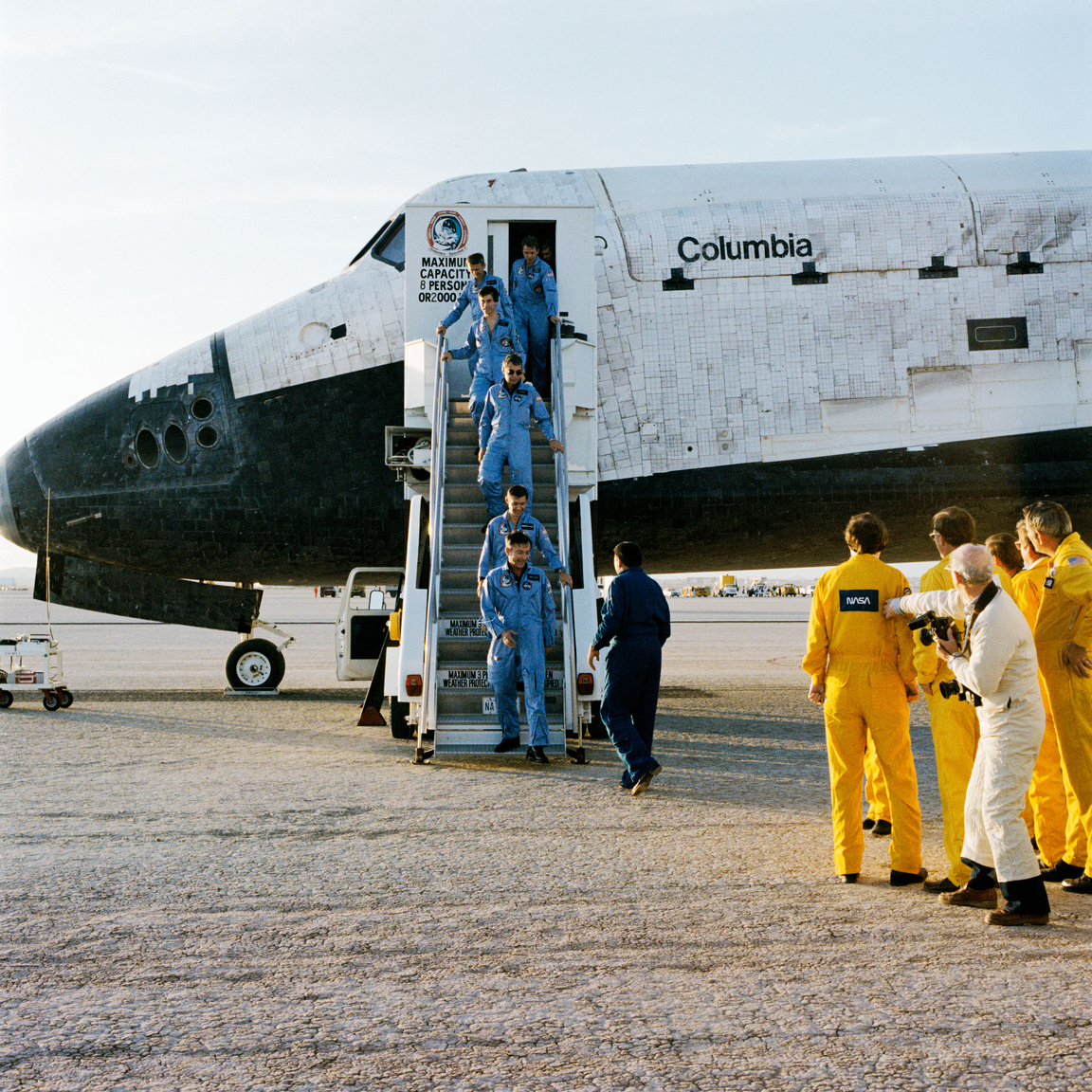 1983. december 8. A tíz napig tartó STS-9 űrsiklóküldetés hatfős legénysége kiszáll a Columbia űrrepülőgépből az kaliforniai Edwards légibázison. Az élen John W. Young parancsnok, őt a pilóta Brewster H. Shaw követi, majd sorban mögöttük Robert A. R. Parker; dr. Ulf Merbold; Owen K. Garriott és dr. Byron K. Lichtenberg specialisták. A nyugatnémet dr. Merbold volt az Európai űrügynökség (ESA) első űrhajósa, aki amerikai űrhajón utazhatott. 