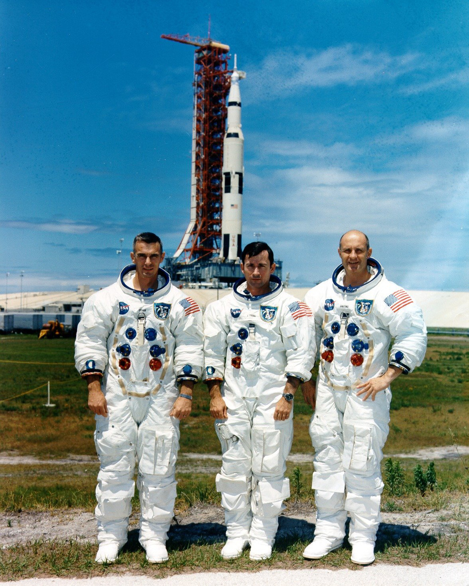 Az Apollo-10 holdküldetés űrhajósai: Eugene A. Cernan (holdkomppilóta), John W. Young (parancsnoki modul pilóta) és Thomas P. Stafford (parancsnok), 1969. május 13-án, a startra kész Saturn V rakéta előtt.