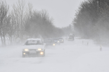 Autók közlekednek a hófúvásban a Hajdúnánás és Hajdúdorog közötti úton.