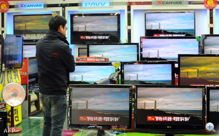 Dél-koreai férfi nézi a japán híreket egy elektronikai szaküzletben