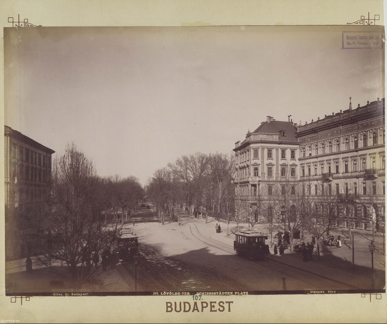 A Lövölde tér a századforduló előtt. Vajon ott akkor is „köd ült a zugokban,
                        és fújt a szél a liget felől unottan”? A térnévadó céllövöldét 1890-ben elbontották, a teret megnagyobbították és körben bérpalotákat építettek. A ma is itt álló műemlék, régi villamoskocsikra emlékeztető nyilvános illemhely („zöld villamos”) fontos szerepet kap az idei Budapest100-on. A Város Mindenkié csoport erre a tematikára építette szombati programját Közvécéket Budapestre – Kis dolog is lehet nagy dolog! címmel és lesz kis budapesti kloákatörténet is.