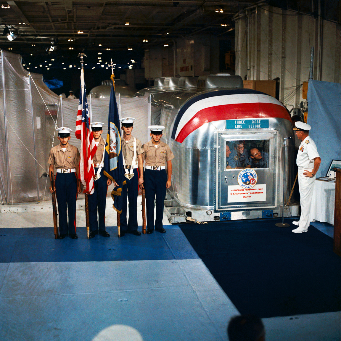 1969. november 24. Donald C. David admirális üdvözli a Holdról visszatért három űrhajóst a USS Hornet repülőgép-hordozó fedélzetén, a speciális elkülönítő-egységben. 