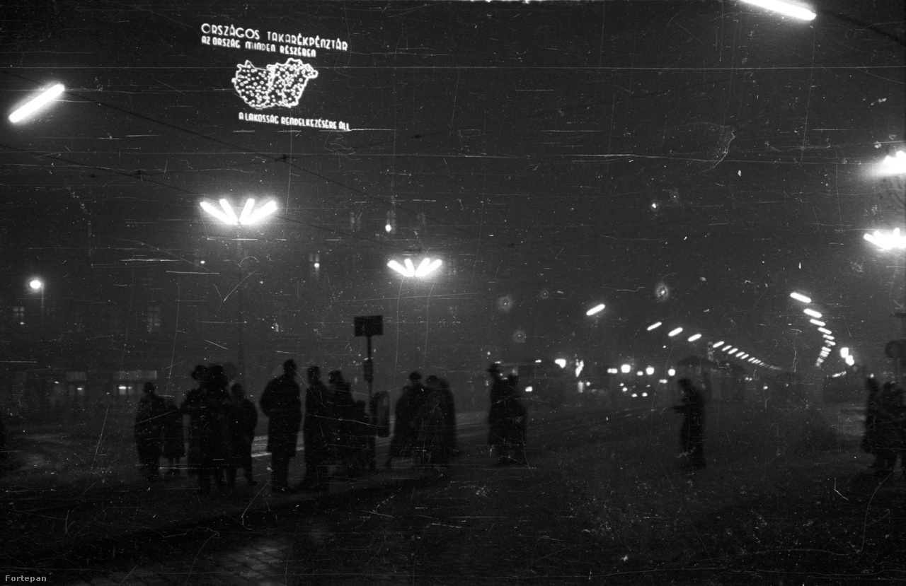 Éjszakai kép 1959-ből: az OTP neonja mellett neoncsöves utcalámpák világítják be a nyolcszögletű teret.
                        