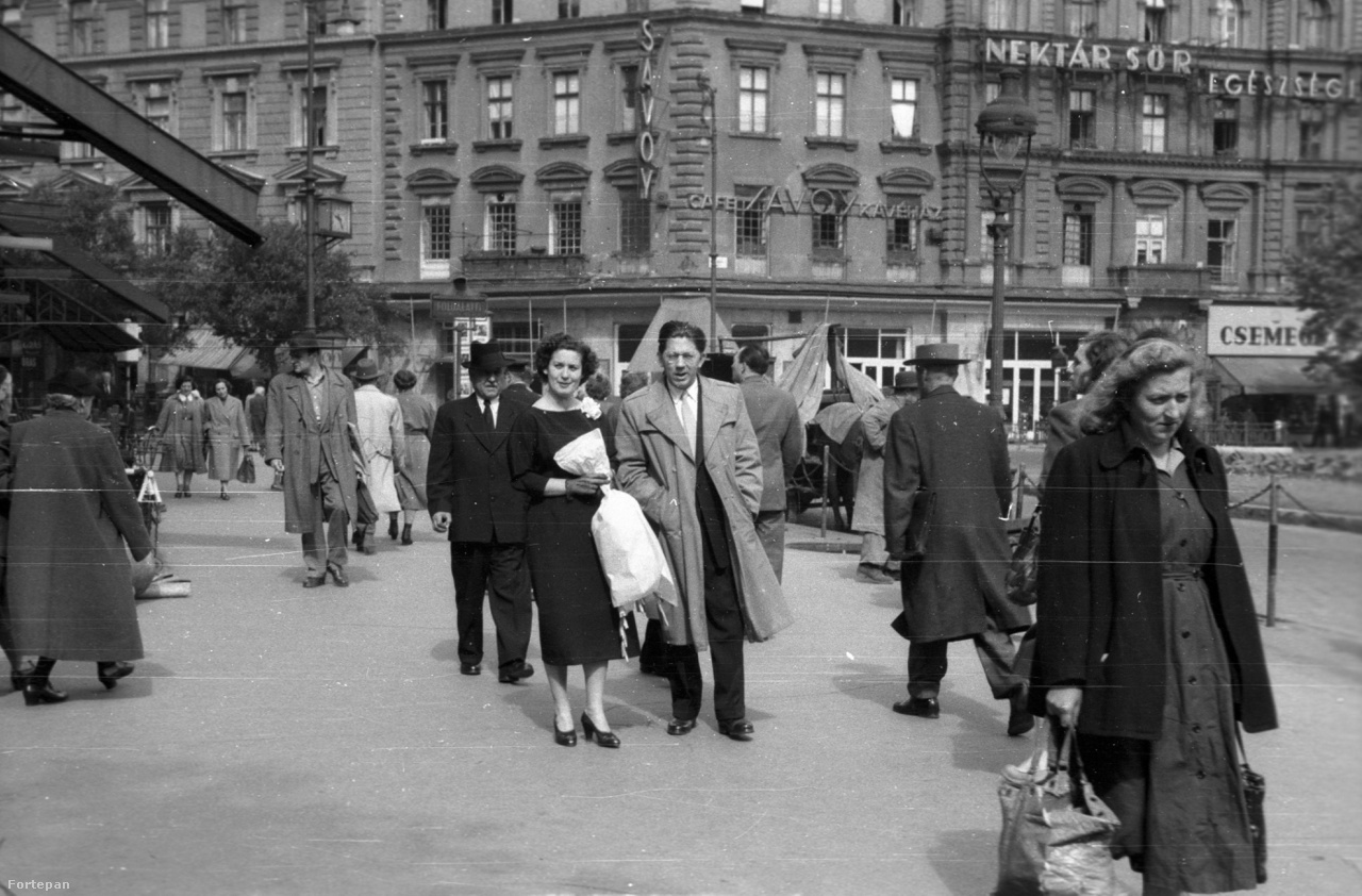 Kicsit ereszkedjünk le a járókelők közé ennek az 1946-ban készült kép segítségével. A fotós az Abbázia kávéház felől a Savoy kávéház felé nézve örökítette meg az elegáns, virágcsokros párt. Jobbra fölül egy a Nektár Sör egészségességét hirdető neon látható.