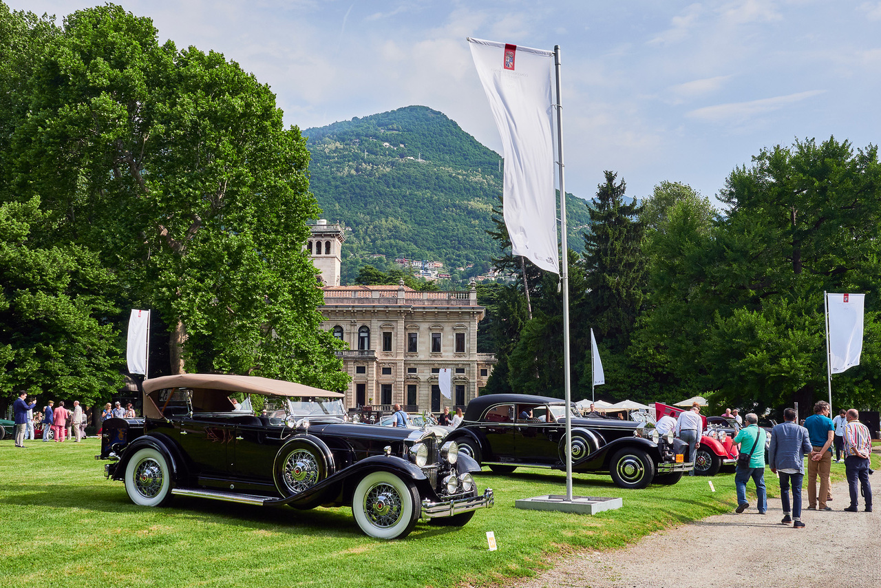 Packard Standard Eight, 1932 és Rolls-Royce Phantom II, 1933. Vasárnap reggeli látkép a Villa Erba területén, mielőtt ellepi a tömeg. Ez a két kocsi is “Az autós gazdagság aranykora” kategóriában indult. A Packard a közelmúltban hibátlanul végigment egy 1200 mérföldes, 14 százalékos emelkedőkkel tűzdelt túrán, 38 fokban. Azt nem tudni, hány ilyen Rolls készült, valószínűleg legalább kettő, legfeljebb négy. 