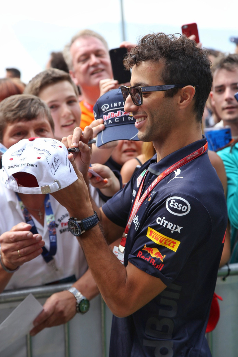 Ricciardo szokás szerint mind a száznegyvennyolc fogával vigyorogva szórja a poénokat, 
                        osztja az autogramokat. Ha kell, még a telefont is kikapja a rajongók kezéből, hogy ő 
                        készítse el az örök emléket számukra, minél jobb szögből. Több ilyen jó értelemben vett 
                        bohócra lenne szükség, a sótlan, bemerevedett, önmaguk nagyságától elájuló sztárok meg 
                        kereshetnének más elfoglaltságot maguknak. Ez showbiznisz, amit a rajongók tartanak el, ha
                        tetszik, ha nem.