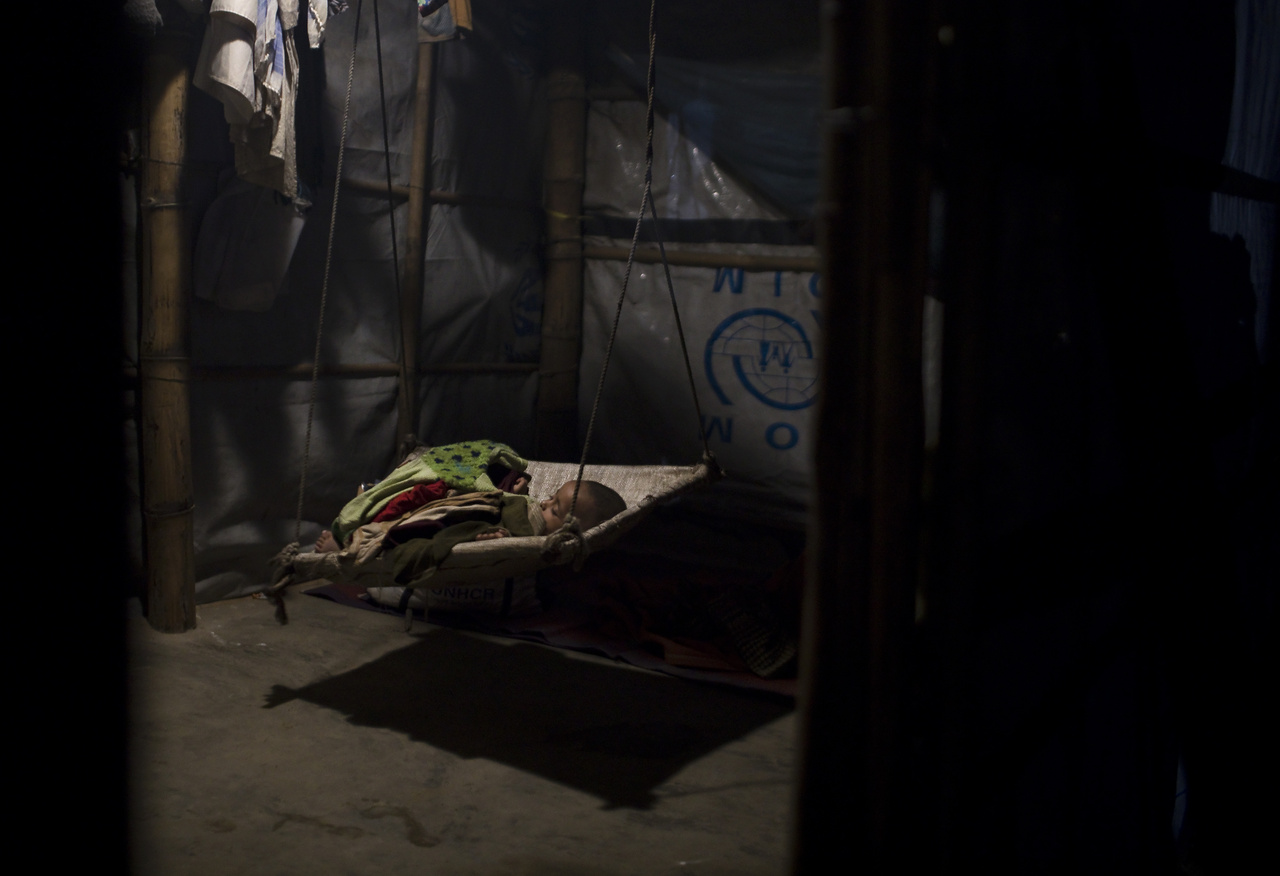 A 2 éves Abad alszik a családi sátorban felállított hintában. Kis területen olyan gyermekek százezrei zsúfolódtak össze rossz higiéniás viszonyok mellett, akik soha, semmilyen oltásban nem részesültek, így teljesen védtelenek a betegségekkel szemben.  