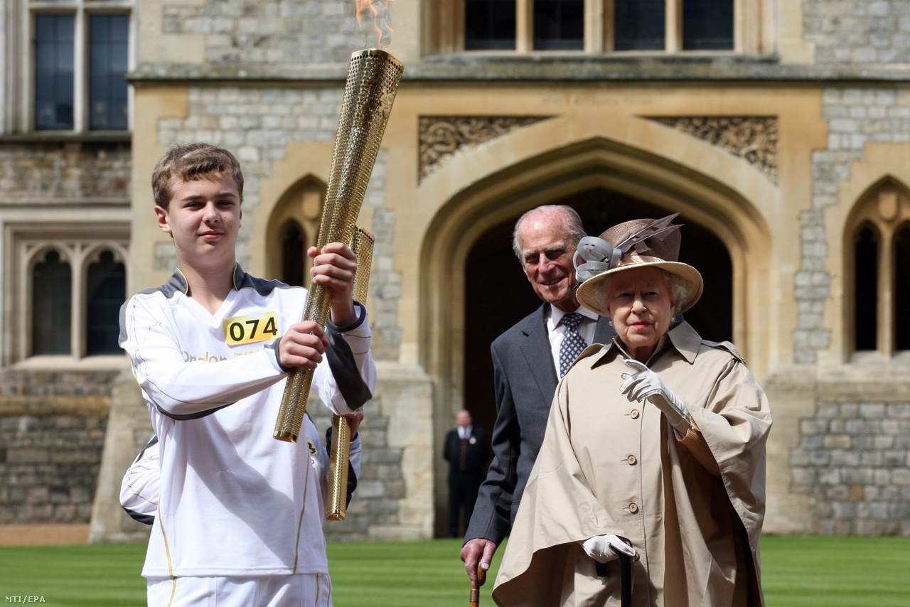 II. Erzsébet és Fülöp herceg Phillip Wells 14 éves rögbijátékossal áll a windsori kastély előtt az olimpiai lánggal a 2012-es londoni olimpia kezdete előtt.